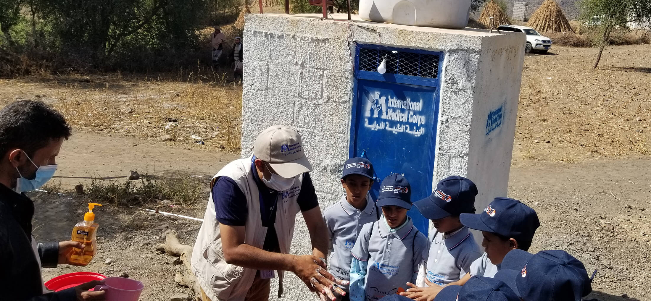 Children in Alkorshoob village learn how to use a new water point, where they can now access clean water to wash their hands without leaving their village.