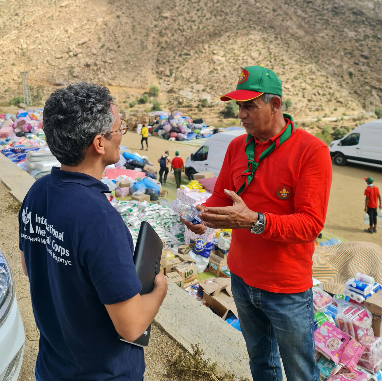 International Medical Corps is partnering with local organizations to distribute hygiene kits, family tents, solar kits, plastic sheeting, and winter clothing and shoes to support affected communities.International Medical Corps’ Emergency Response Team Medical Coordinator meets with a member of the Scouts of Morocco at the distribution in Falghous.