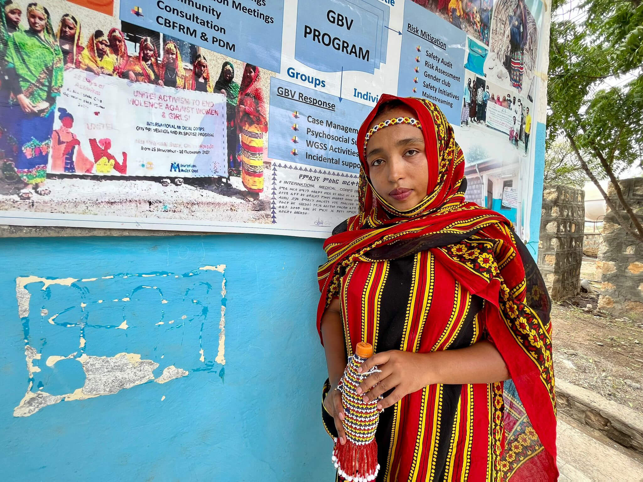 Sofia Seid, an International Medical Corps Assistant GBV Response Officer, stands in front of the WGSS in Chifra. She’s dressed in the traditional clothing of the Afar region.