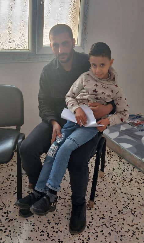 Muhammad sits on his father’s lap at the Shuhada Algurgof primary health centre.
