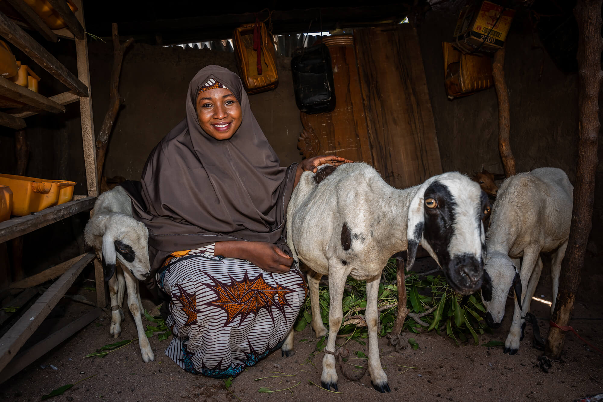 Asmau Sambo rests at home with her goats.